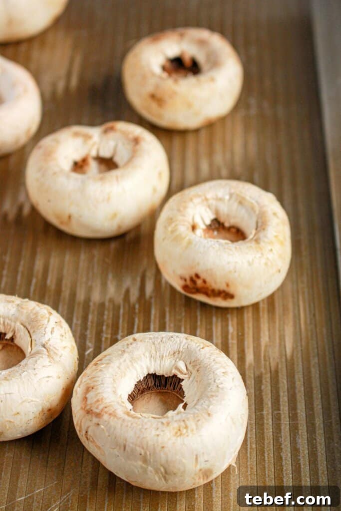 Cream Cheese Stuffed Mushrooms Recipe with Garlic and Herbs 5 Mushrooms on a baking pan.