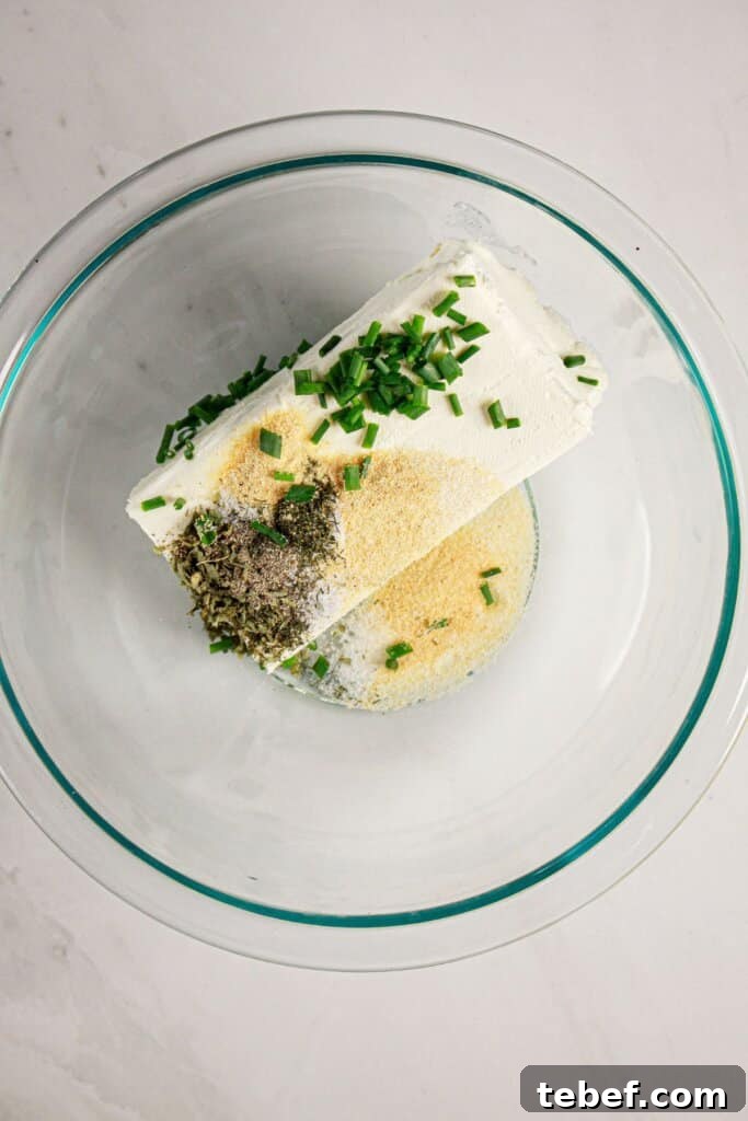 Cream Cheese Stuffed Mushrooms Recipe with Garlic and Herbs 6 Cheese and seasonings being mixed together in a glass mixing bowl.
