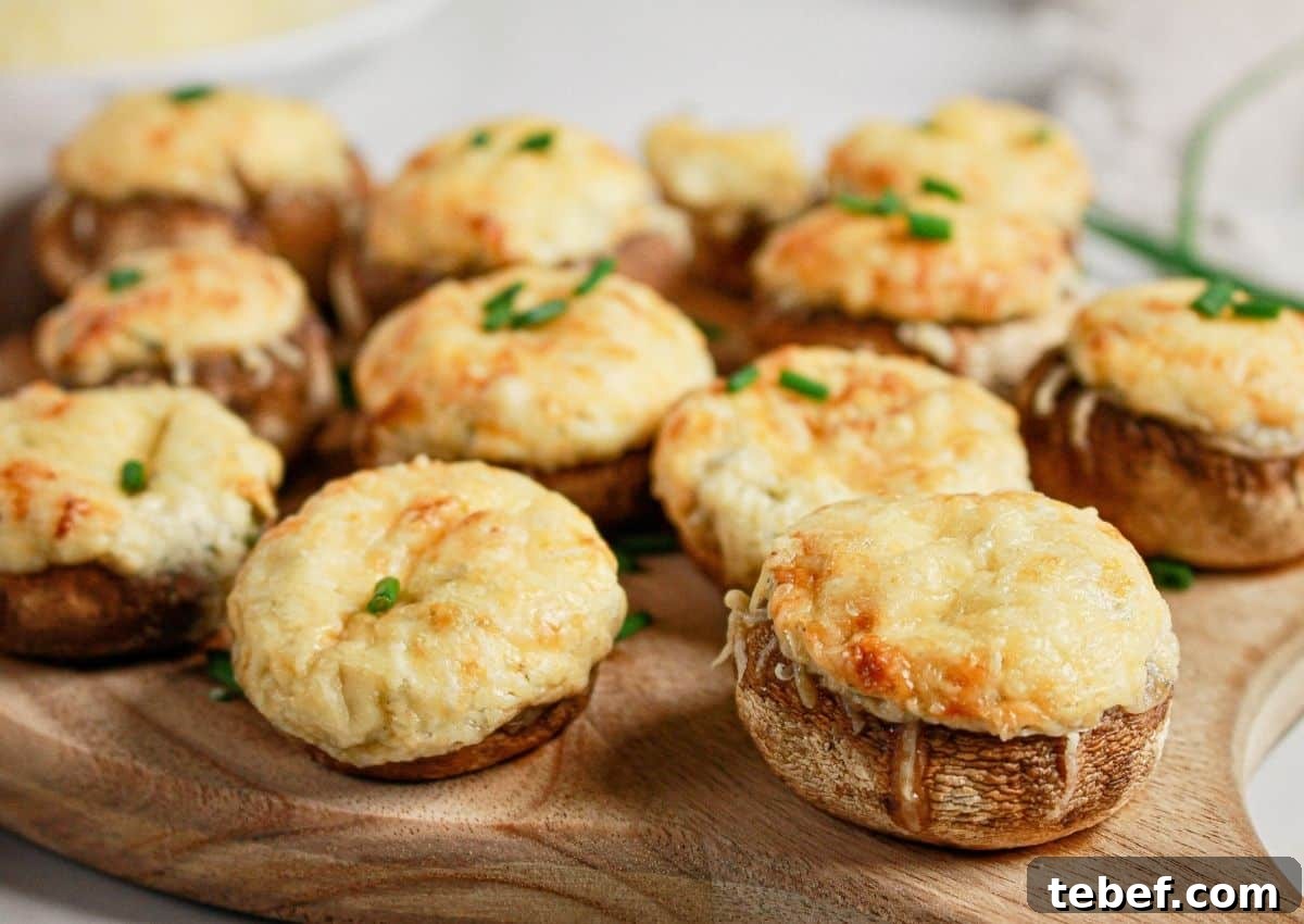 Cream Cheese Stuffed Mushrooms Recipe with Garlic and Herbs 9 Cream cheese stuffed mushrooms on a wooden cutting board.