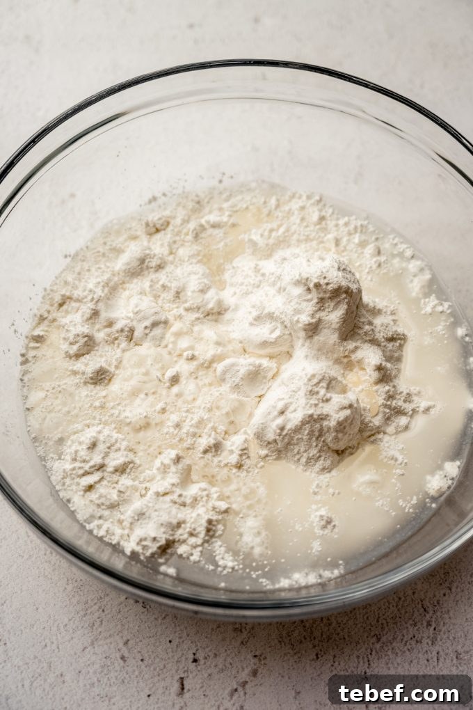 Decadent Strawberry Swiss Roll Recipe with Cream Filling 7 A glass bowl of the ingredients to make the sponge cake base for a Swiss roll cake.