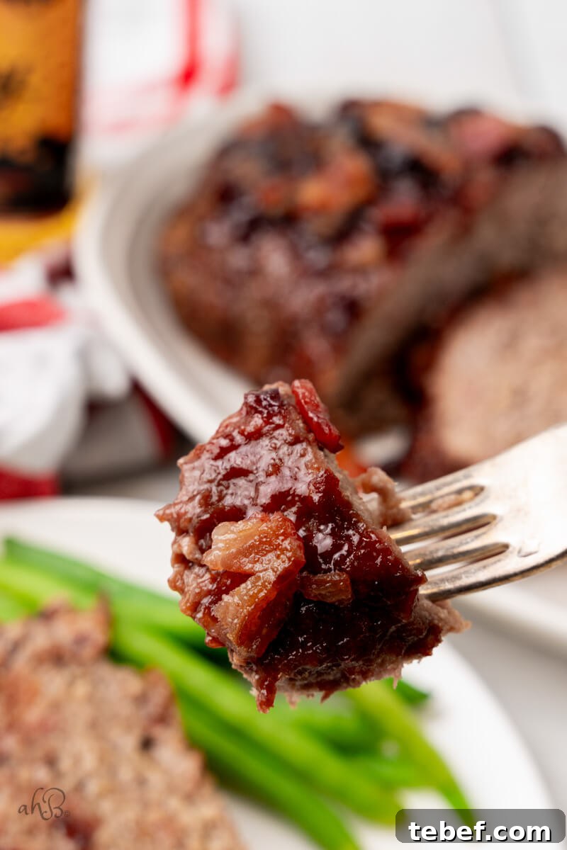 Bacon Bourbon Meatloaf-31 A bite of bourbon bacon meatloaf is held on a fork.