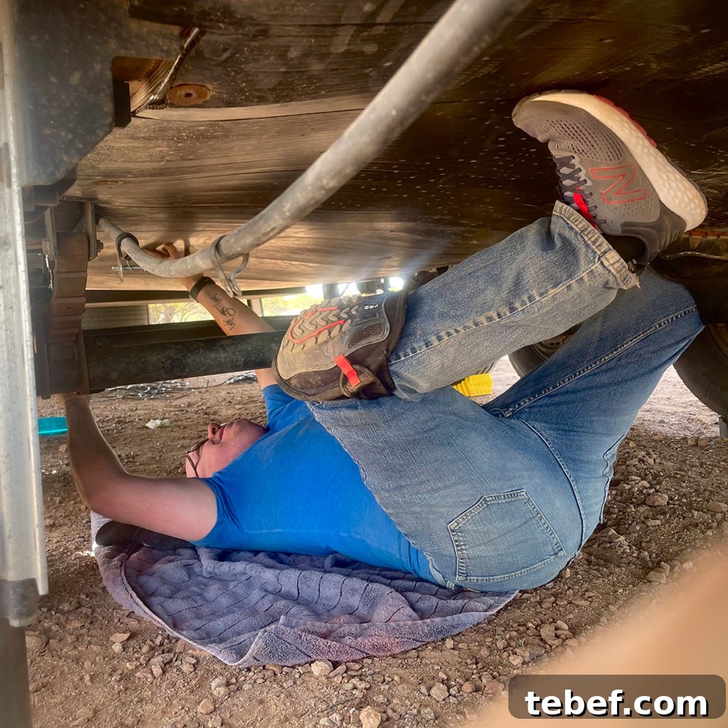 Lost Together: March 2022 Travel Stories and Highlights 14 A photo of Steve laying on his back underneath our RV to make repairs.