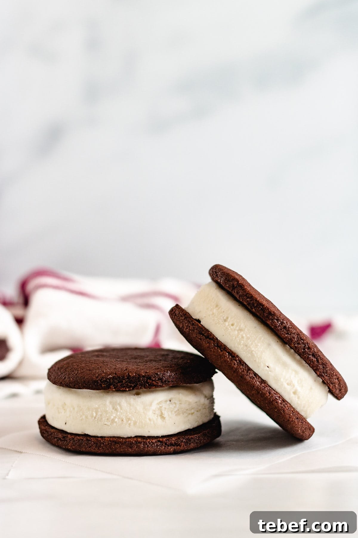 Two ice cream sandwiches on parchment paper.