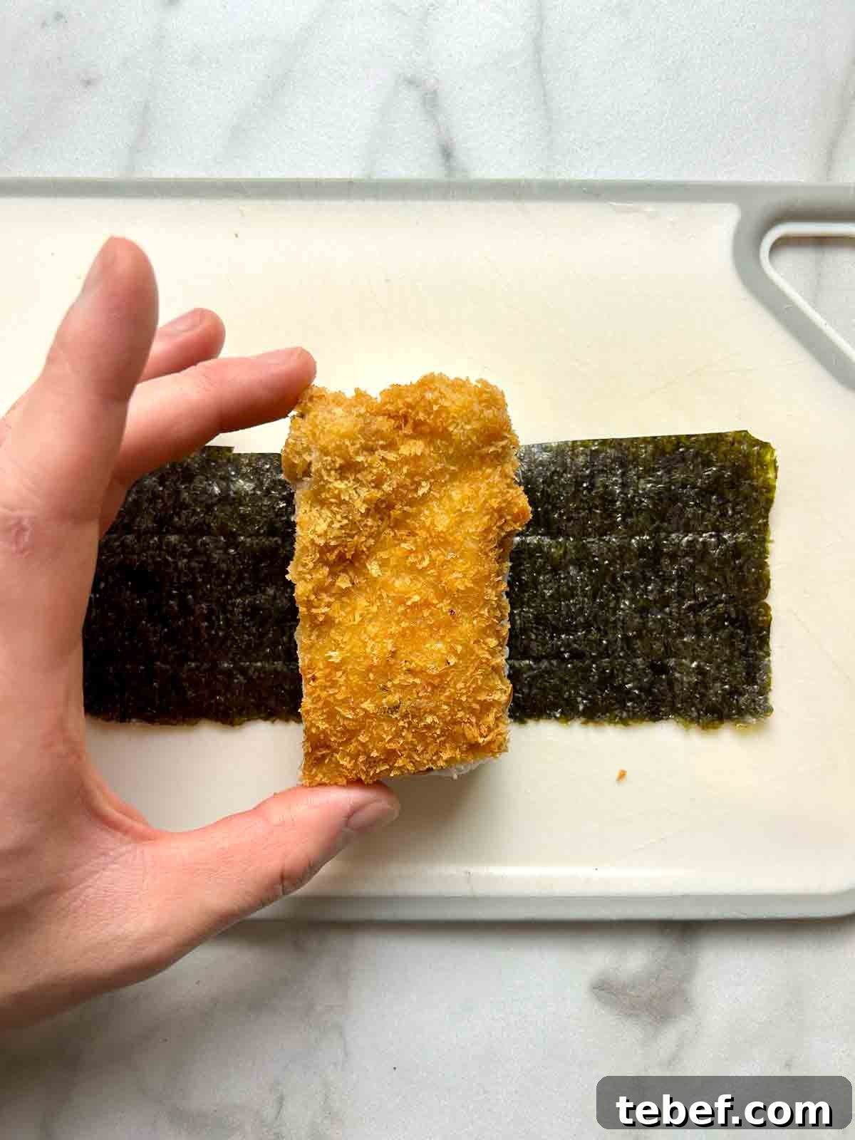 Chicken Katsu Musubi Recipe: How to Make Japanese Fried Chicken Rice Balls 14 piece of chicken katsu being placed onto rice