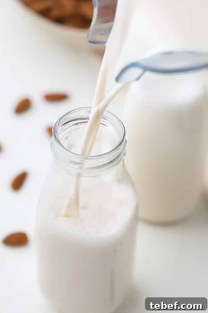 Almond Milk from Soaked Almonds: Quick Soak Method Guide 2 milk pouring into glass bottle from blender