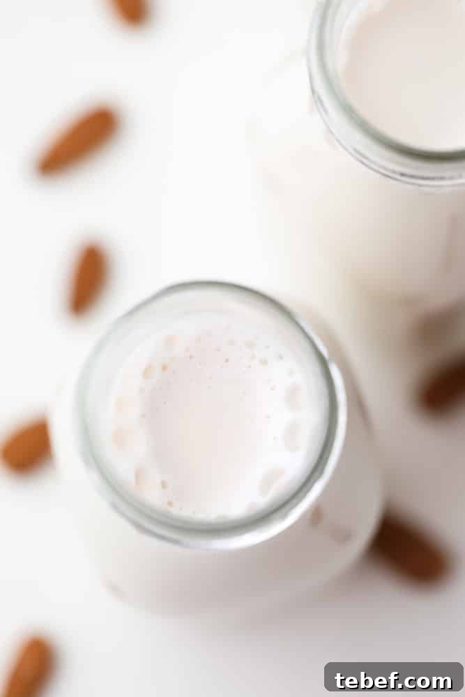 Almond Milk from Soaked Almonds: Quick Soak Method Guide 3 looking down on a bottle with white milk, almonds in background