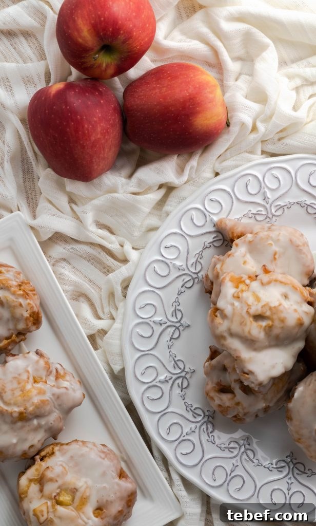 Crispy Homemade Apple Fritters Recipe for Irresistible Fall Treats 5 Three apple fritters on rectangular plate and stacked fritters on decorative round plate.