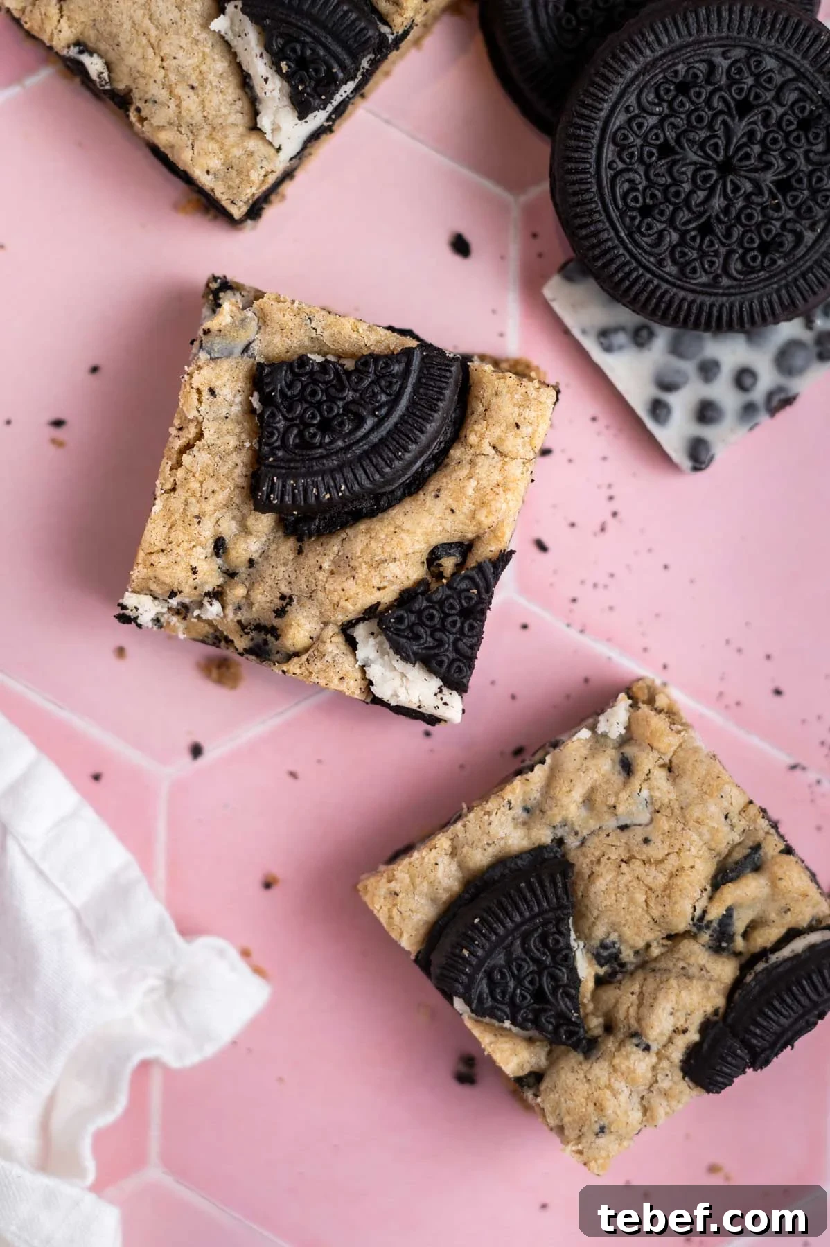 bar cookie squares on a counter with a napkin and extra cookies and candy bars