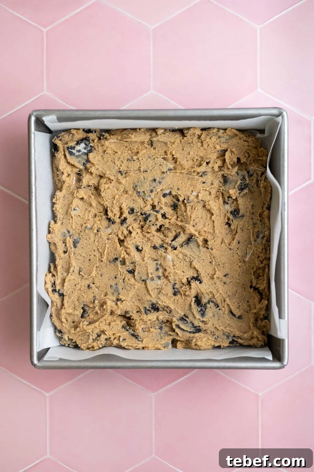 cookie dough pressed into a parchment lined baking tin