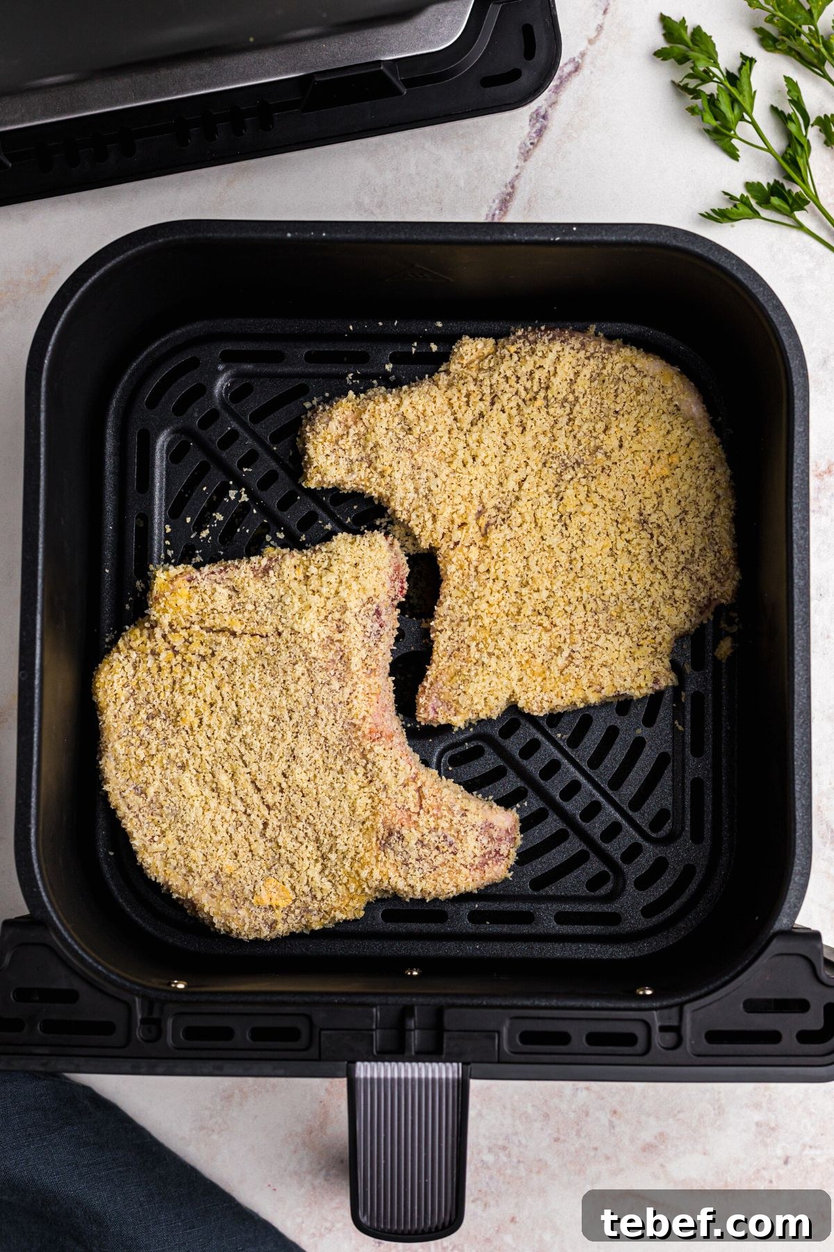 Crispy Gluten-Free Pork Chops in the Air Fryer 7 Coated pork chops in the air fryer basket before being cooked