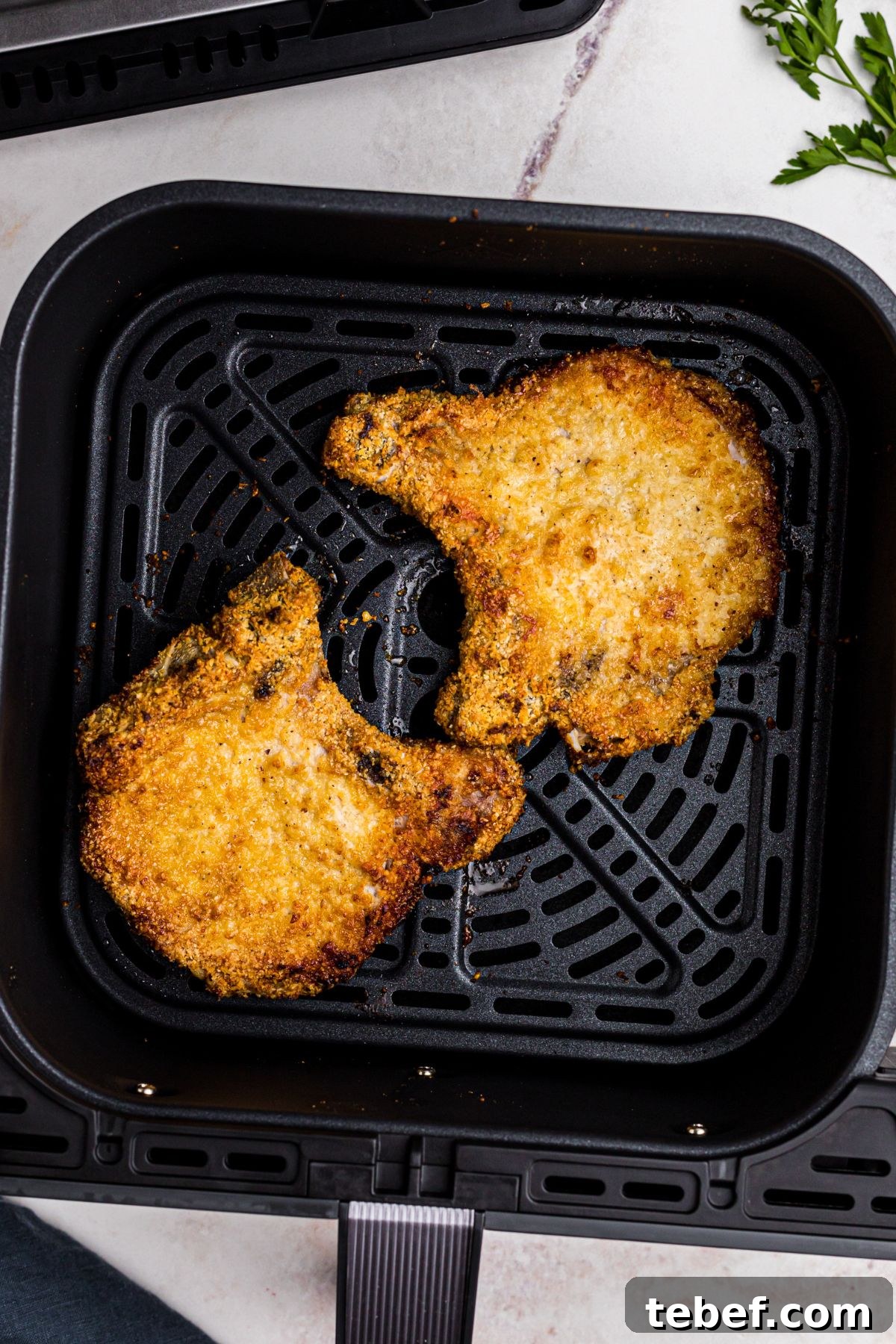 Crispy Gluten-Free Pork Chops in the Air Fryer 8 Golden coated pork chops in the air fryer basket