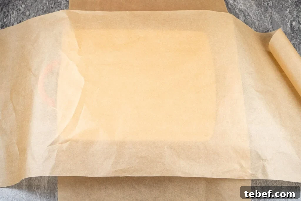 roasting dish with 2 sheets of parchment paper crossed over the top