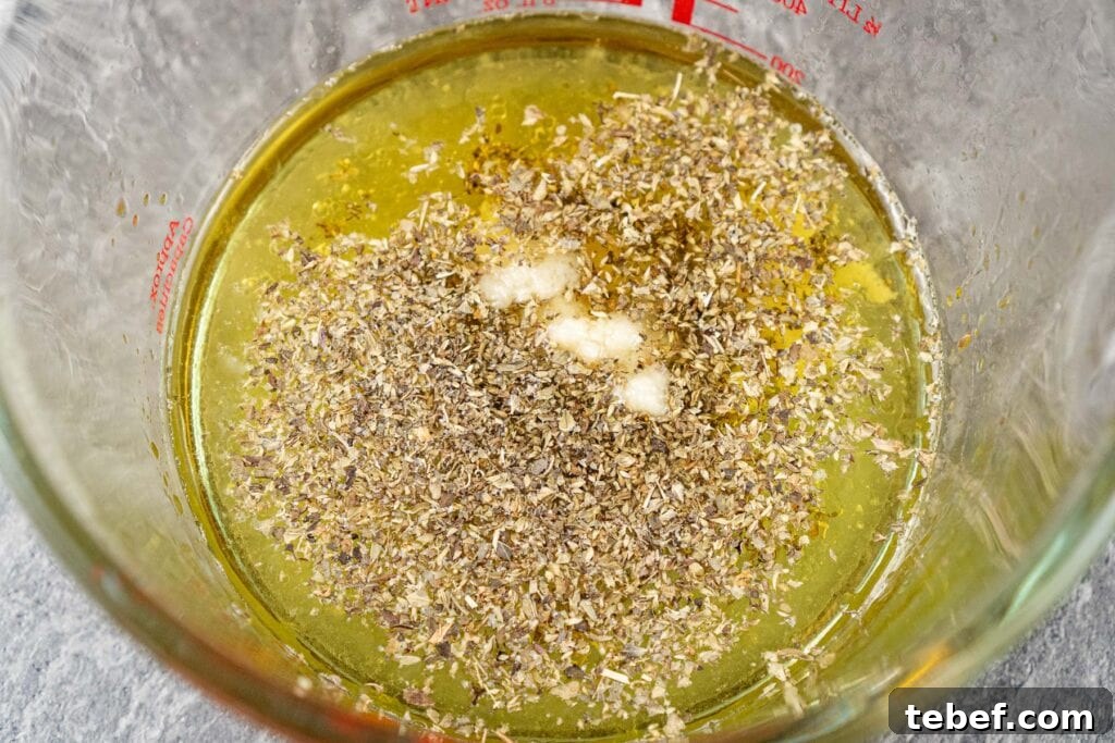 olive oil, lemon, honey, garlic and oregano marinade measured into a jug
