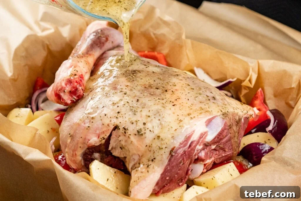 Lamb kleftiko marinade made from olive oil, lemon, honey, garlic and oregano being poured over a leg of lamb