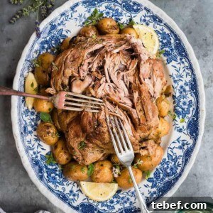 A platter of shredded Lamb Kleftiko with potatoes and lemon slices