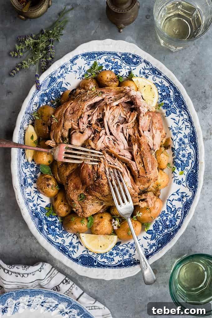 Lamb Kleftiko on a platter with potatoes and lemon slices