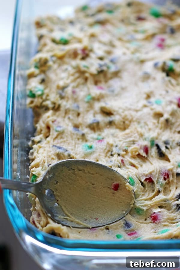 Chewy Cookie Bars Recipe: Gooey Chocolate Chip Squares 3 Spreading out the cookie dough in a 13 x 9 pan with a spoon