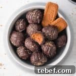 Decadent Biscoff Cookie Butter Truffles Recipe 9 Truffles from above in a grey bowl with biscoff cookies.