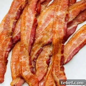 Sheet Pan Pancakes Recipe: Fluffy Oven-Baked Pancake Tray 3 a plate of bacon on a white plate.