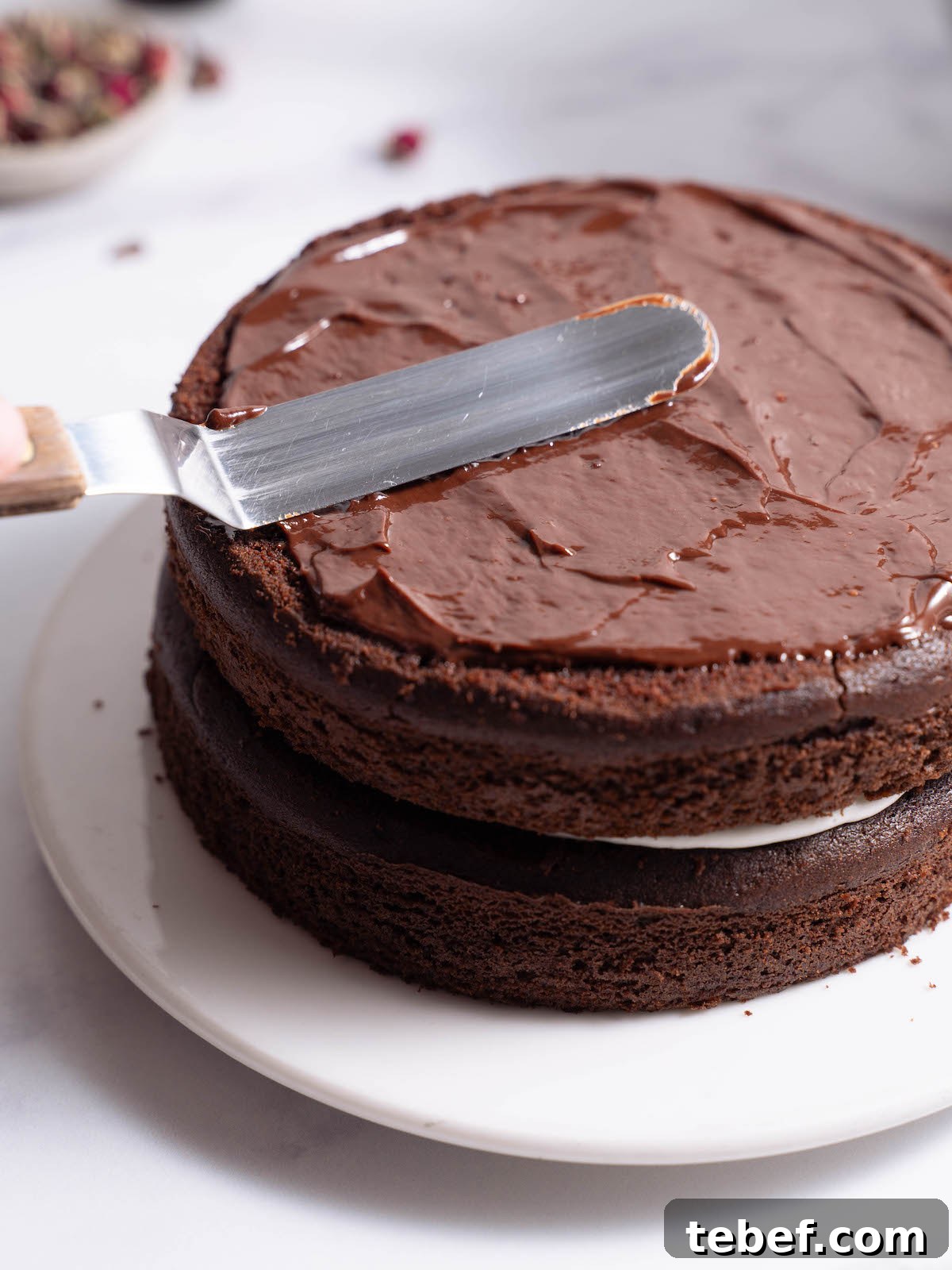 Chocolate Rose Cake with Vanilla Whipped Cream Recipe 6 Spreading ganache onto a cake layer