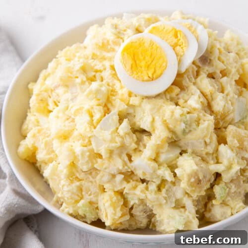 grandma's potato salad in a bowl topped with slices of hard boiled eggs.