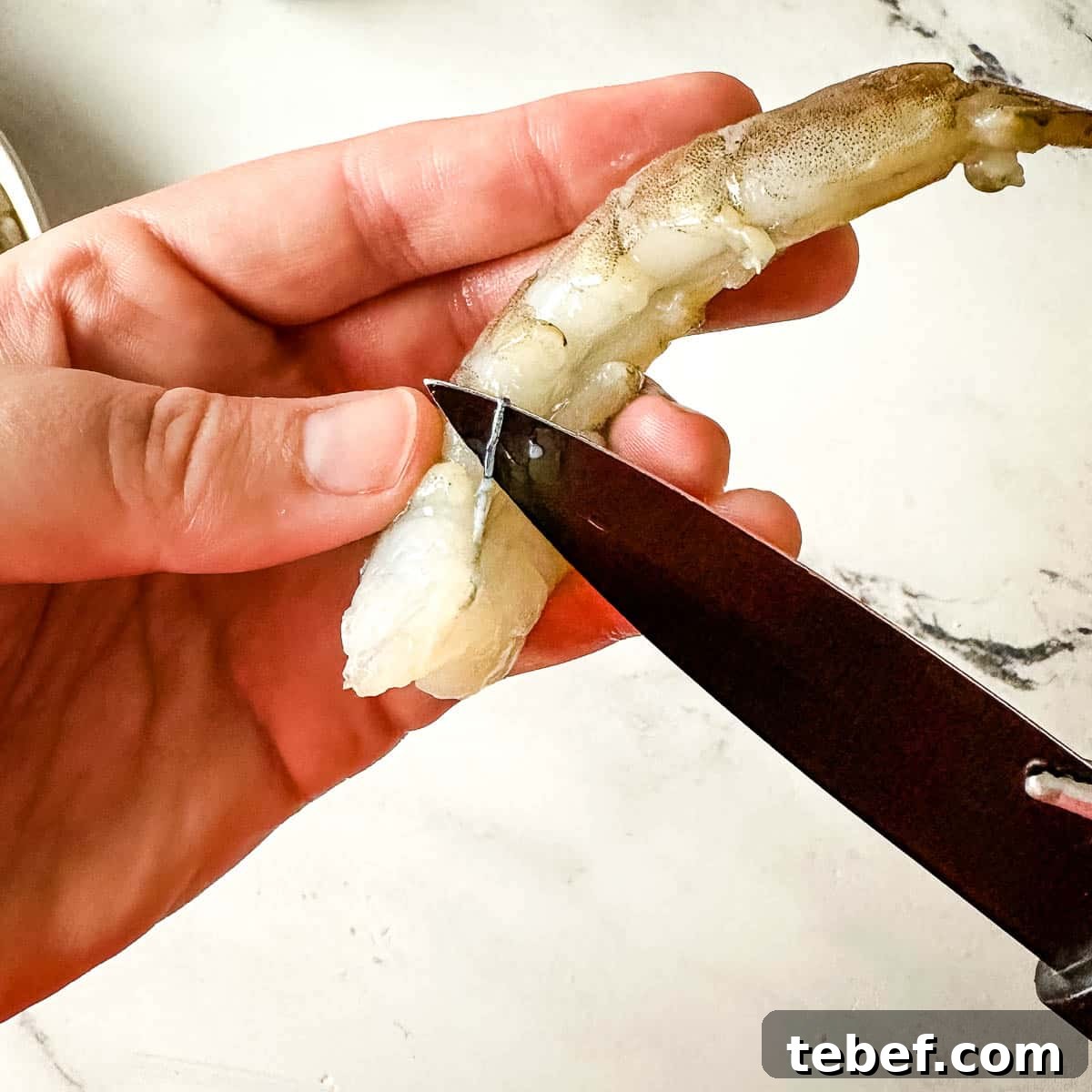 Crispy Beer-Battered Shrimp Recipe — Crunchy Fried Shrimp Guide 3 deveining shrimp with a black paring knife.