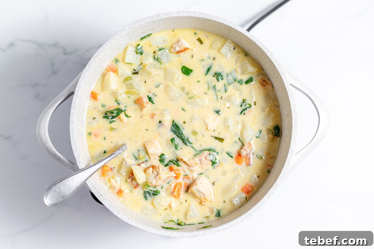 Hearty Chicken and Potato Soup Recipe for Cozy Weeknights 11 Chicken Potato Soup simmering in a large pot.
