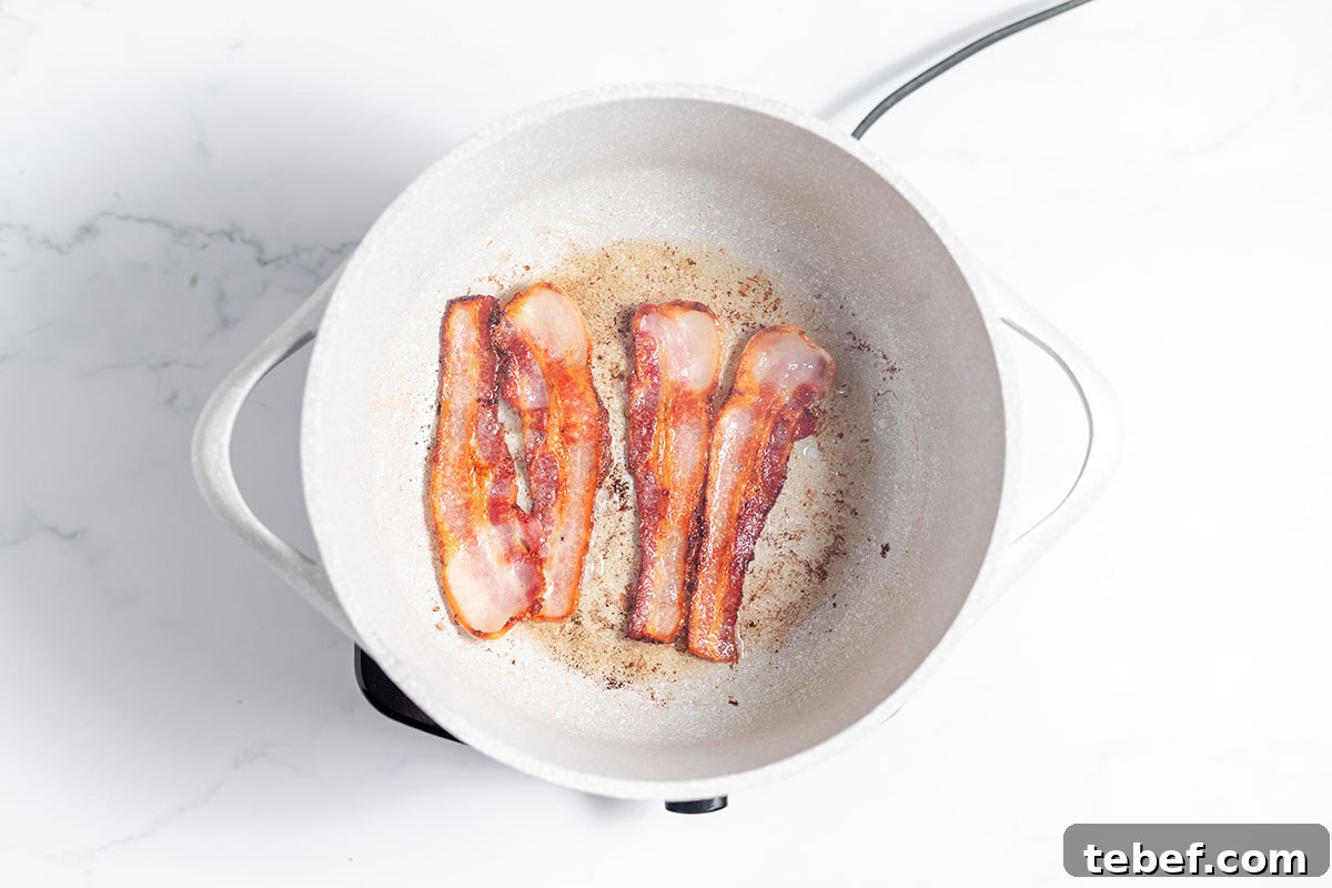 Hearty Chicken and Potato Soup Recipe for Cozy Weeknights 4 Bacon frying in a skillet.