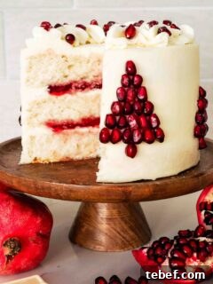White Chocolate and Pomegranate Layer Cake Recipe 19 A white layer cake filled with pomegranate jelly, frosted with white chocolate buttercream, and decorated with pomegranate seeds in the shape of a Christmas tree.