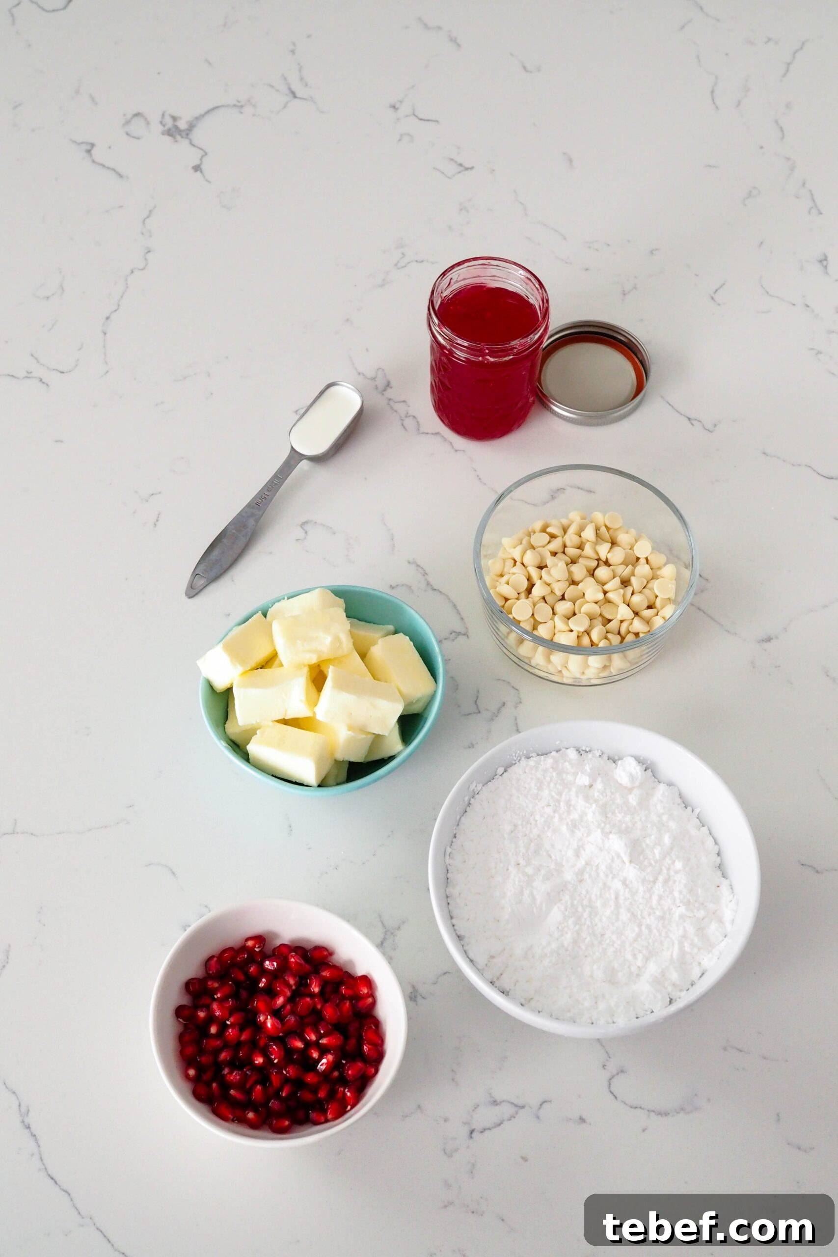 White Chocolate and Pomegranate Layer Cake Recipe 4 Ingredients needed to make the white chocolate buttercream and pomegranate filling laid out on a counter.