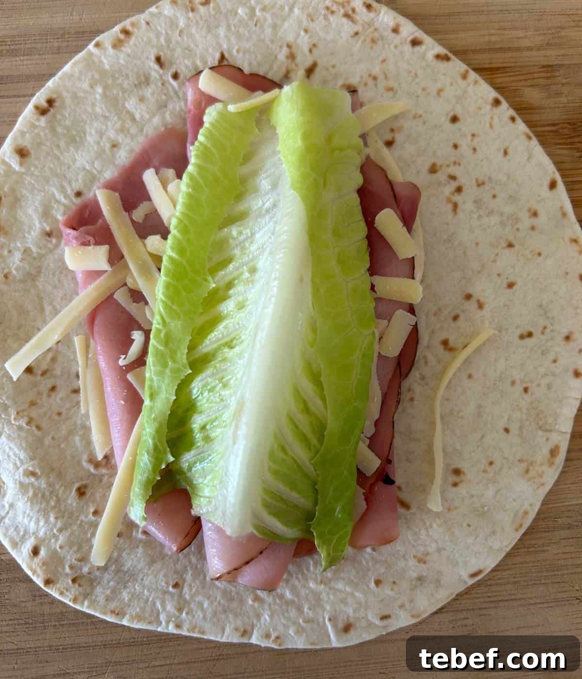 Classic Ham and Cheese Wrap Recipe for Quick Lunch or Snack 6 Loading ingredients on wrap.