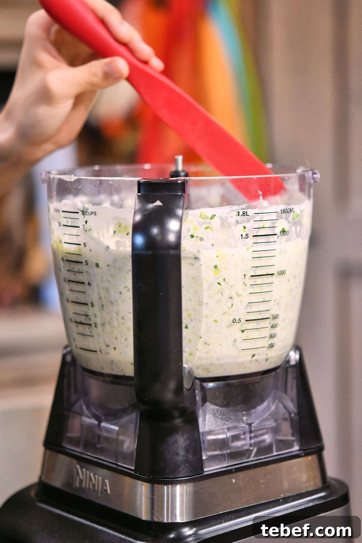 Creamy Zucchini Pasta Sauce Recipe for Light Weeknight Dinners 11 scraping down the sauce along the sides of the food processor