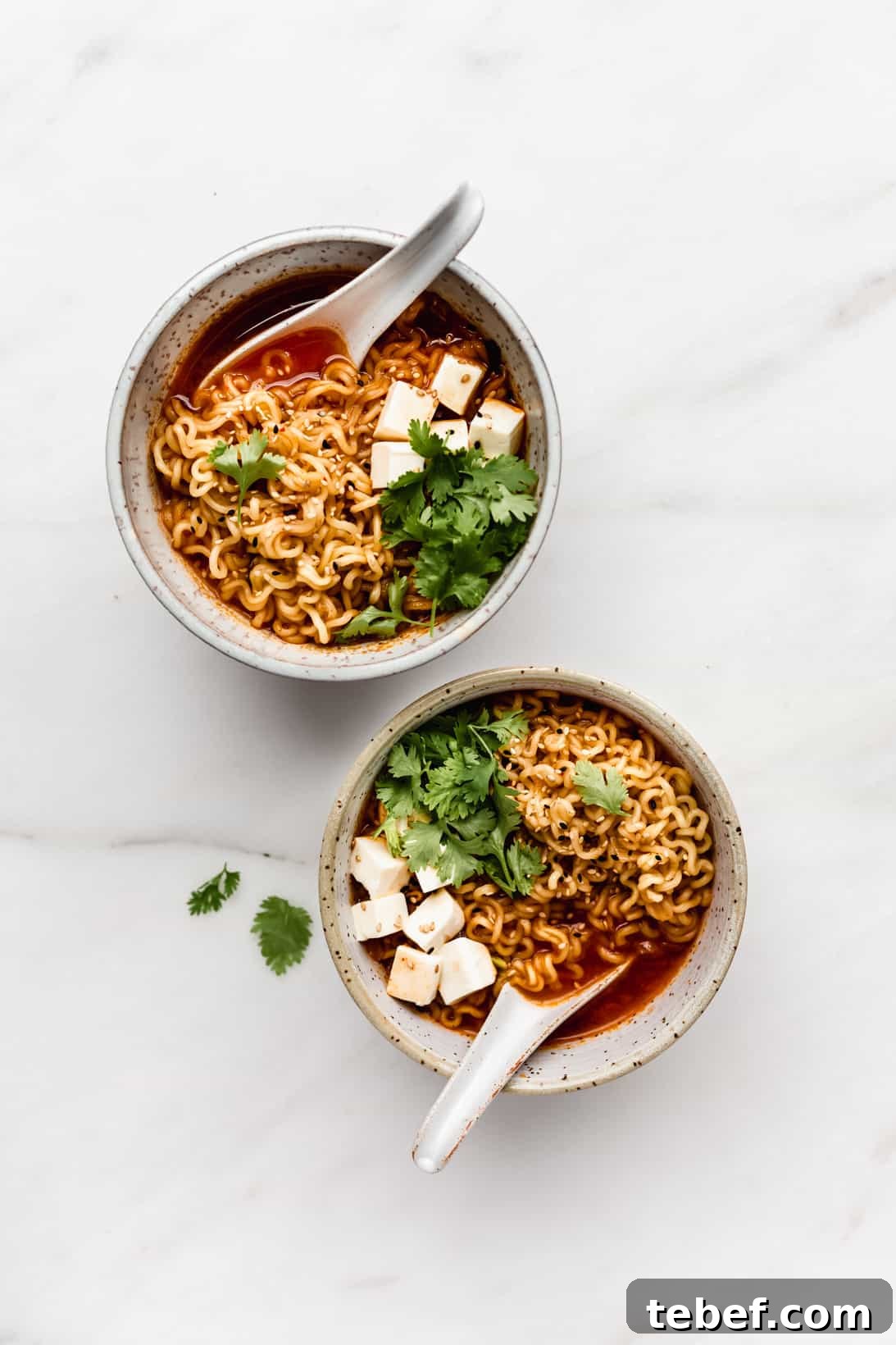 Authentic Kimchi Ramen Recipe: Spicy Korean Noodle Soup Guide 2 two bowls of ramen with noodles, tofu and cilantro