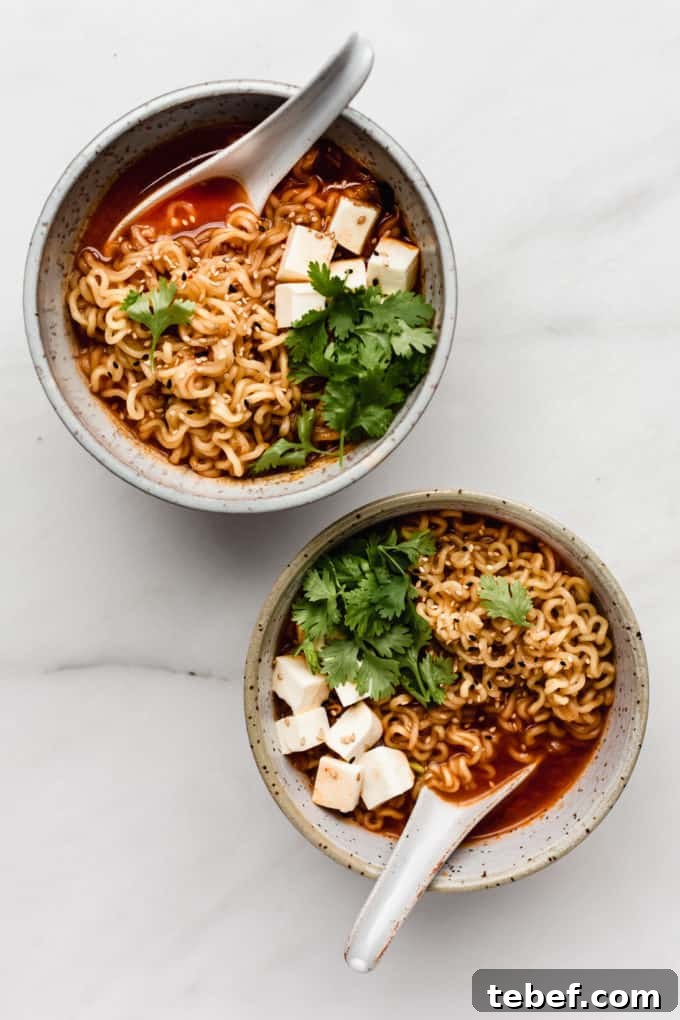 Authentic Kimchi Ramen Recipe: Spicy Korean Noodle Soup Guide 7 two white speckeld ceramic bowls of kimchi ramen with spoons in them