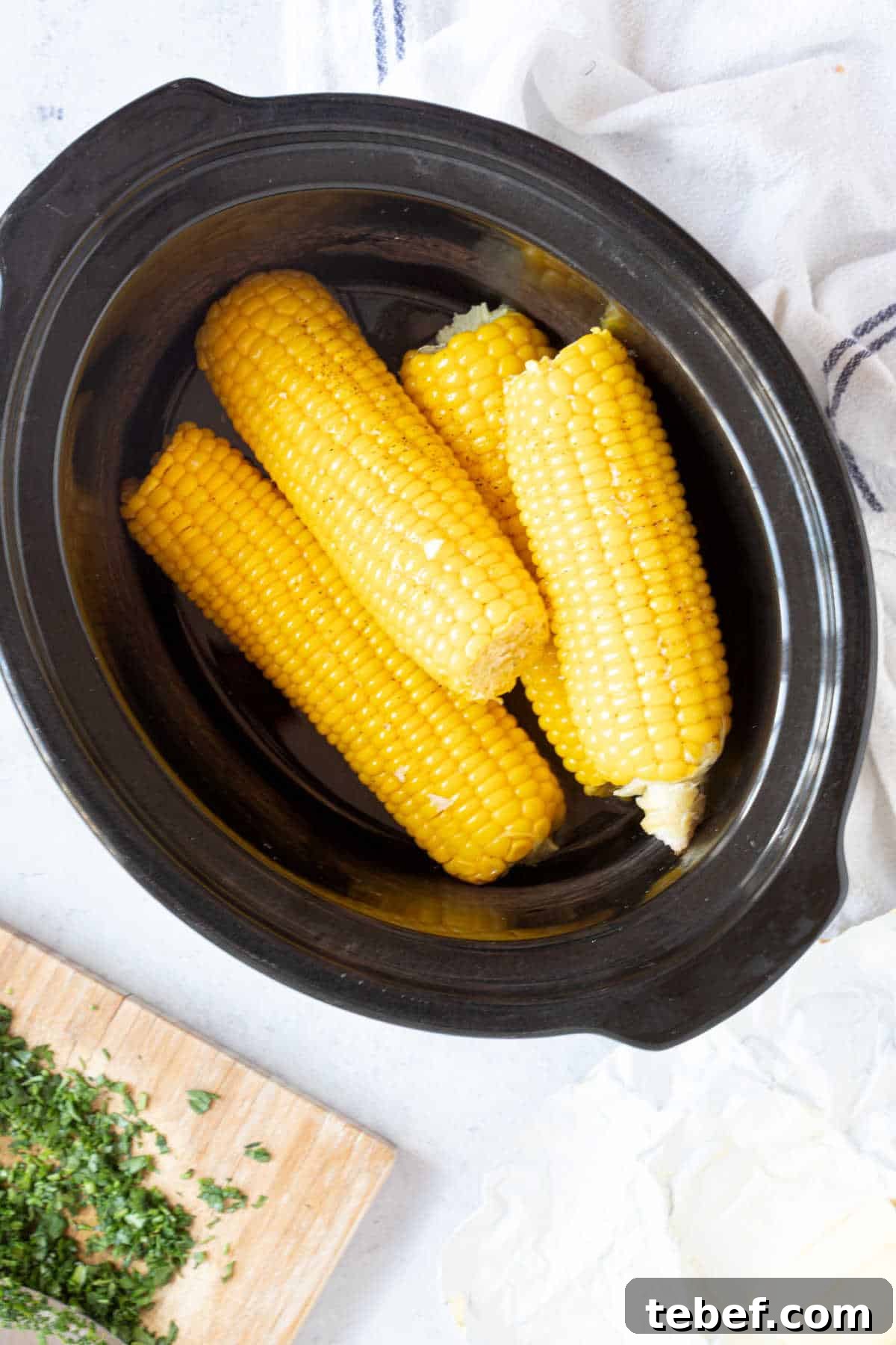 Slow Cooker Corn on the Cob: Tender, Juicy Crockpot Recipe 5 Slow cooker corn in a black slow cooker basin.