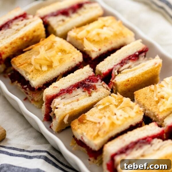 Turkey and Cranberry Croque Monsieur Recipe for Holiday Sandwiches 5 Turkey cranberry croque monsieur sandwiches sitting on white plate with linen napkin underneath on white surface