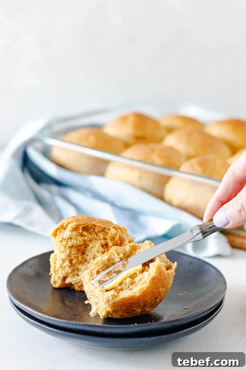 Spreading a swipe of butter on a fresh roll