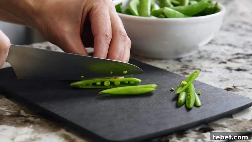 Crisp Sugar Snap Pea Salad with Lemon-Parmesan Dressing 5 hand slicing Sugar Snap Peas with a sharp knife