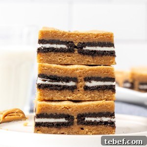 Stack of three peanut butter Oreo blondies with glass of milk