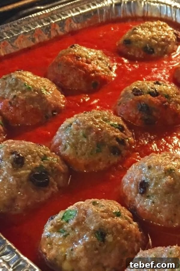 Sicilian-Style Meatballs in Fresh Basil Marinara 4 meatballs baking in tomato sauce