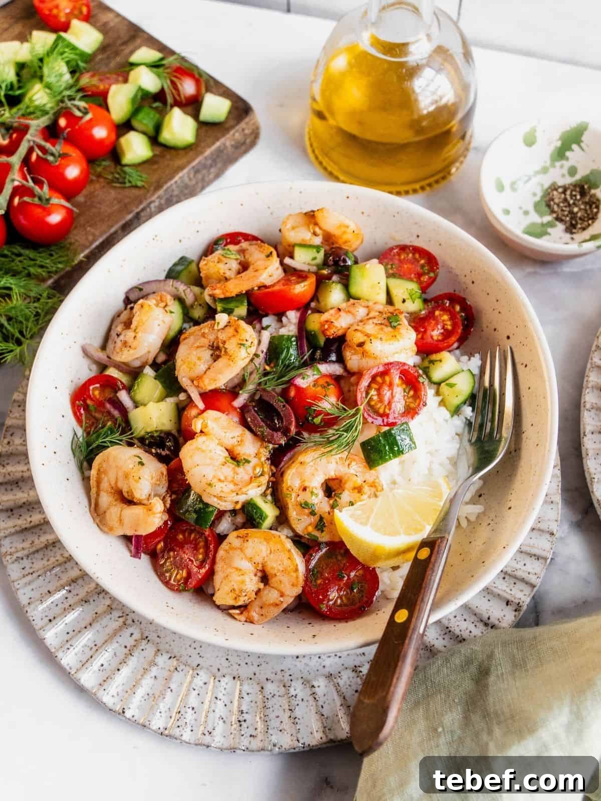 Mediterranean Shrimp Rice Bowl with Fresh Salad 15 Mediterranean shrimp rice bowl with chopped cucumber, tomatoes, olives garnished with fresh dill.