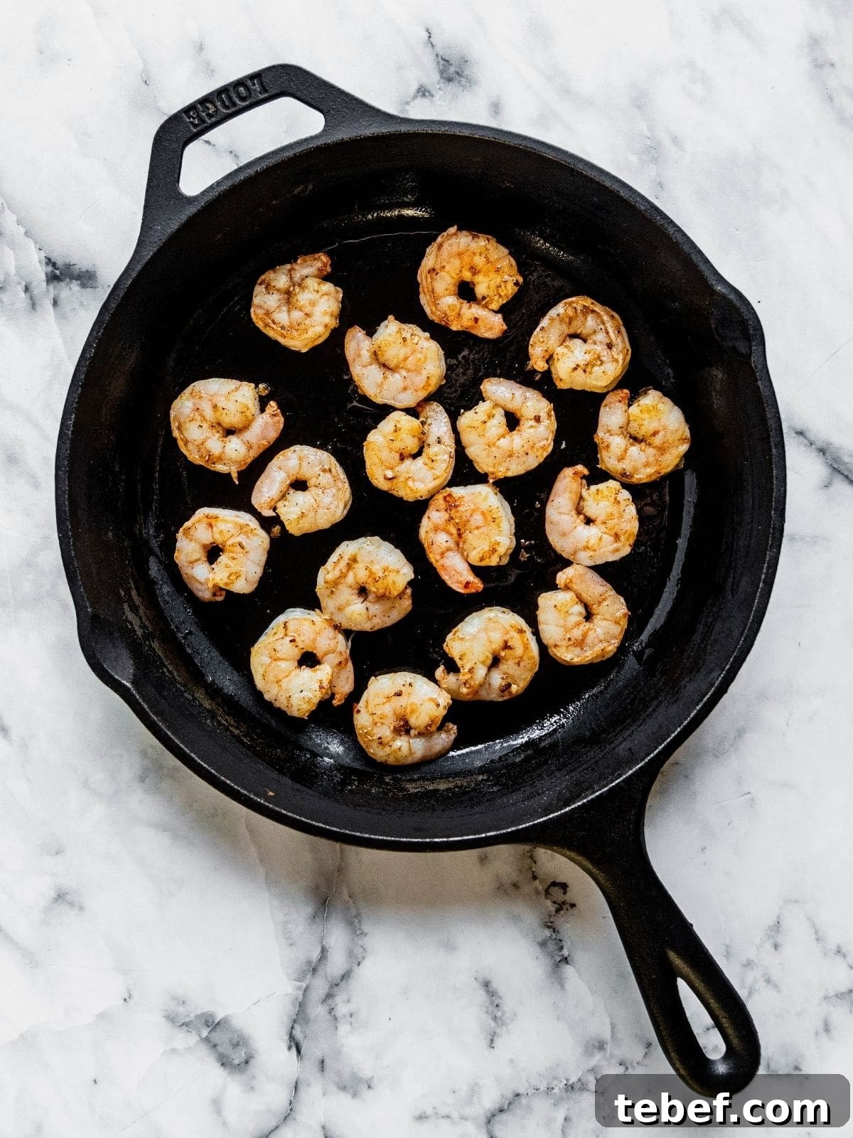 Mediterranean Shrimp Rice Bowl with Fresh Salad 8 Shrimp cooking in a cast iron pan.