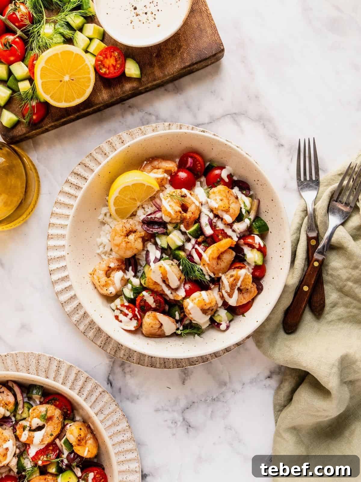 Mediterranean Shrimp Rice Bowl with Fresh Salad 10 Mediterranean shrimp rice bowl with chopped cucumber, tomatoes, olives garnished with fresh dill.