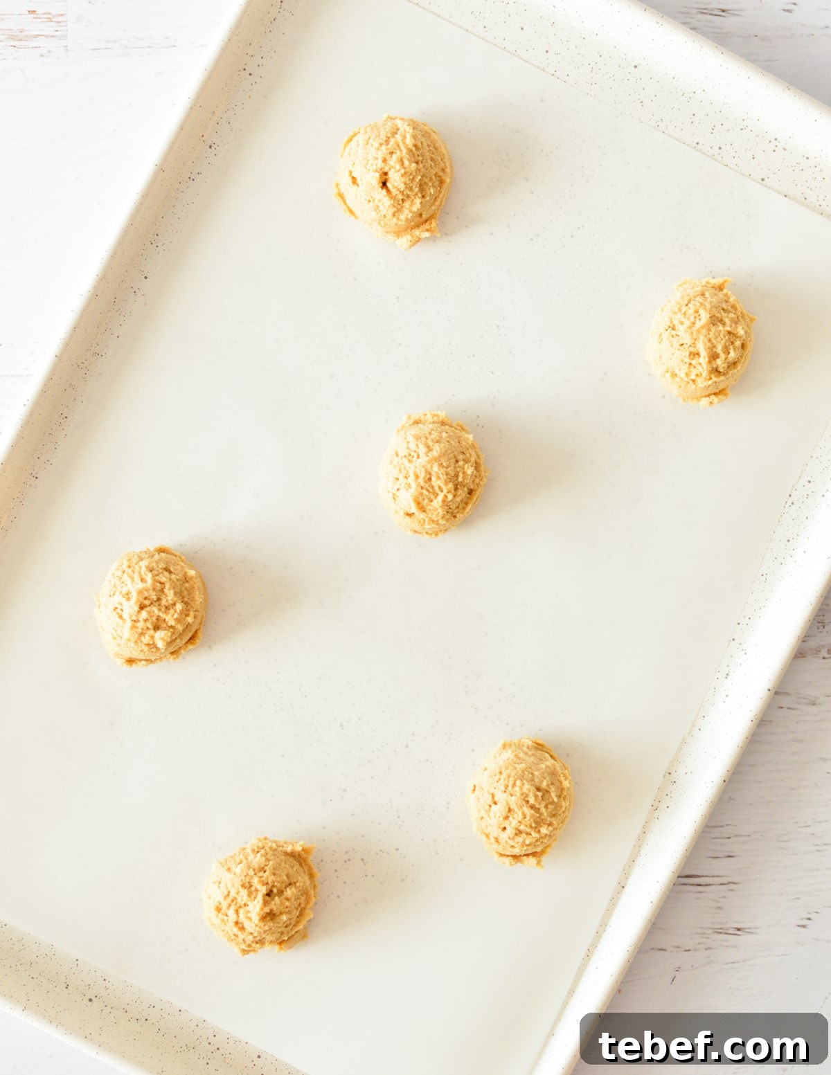 Irresistibly Chewy Peanut Butter Cookie Recipe 9 peanut butter cookie dough balls on sheet pan.