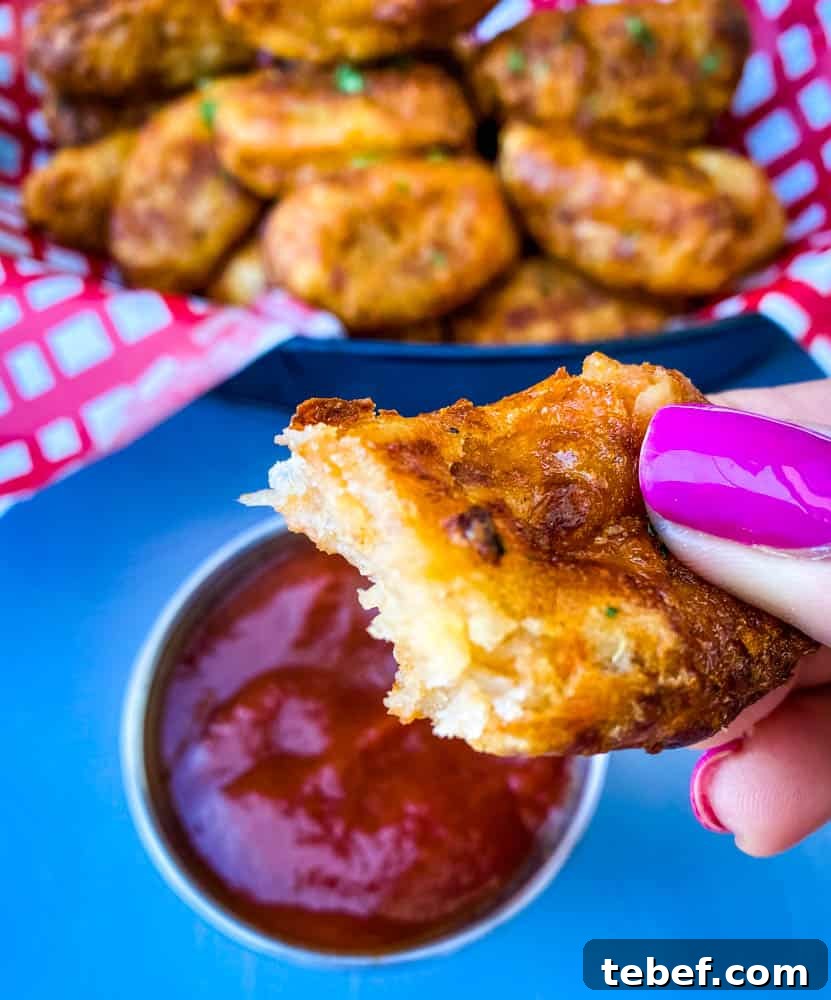 Crispy Air Fryer Tater Tots: Perfectly Golden Every Time 11 person holding an air fryer tater tot with a bite taken out