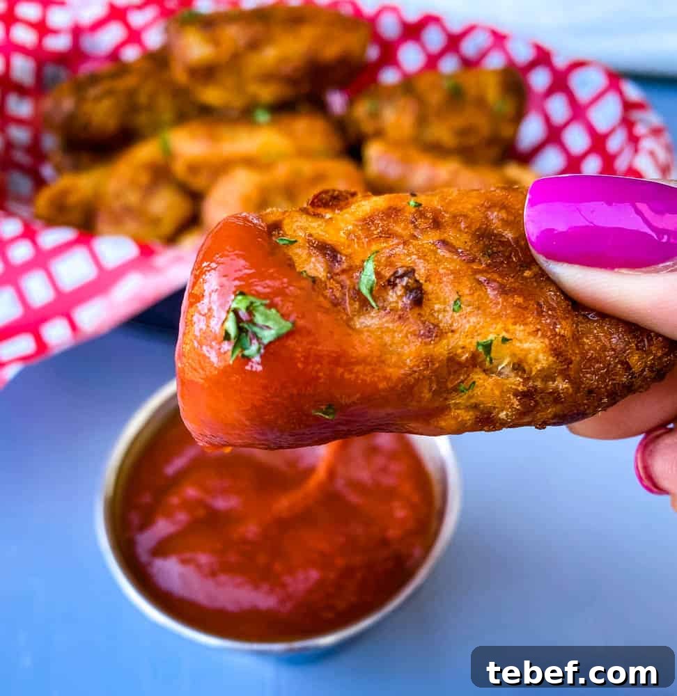 Crispy Air Fryer Tater Tots: Perfectly Golden Every Time 10 person holding air fryer tater tot with ketchup