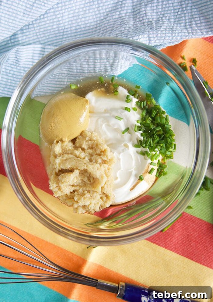 Creamy Horseradish Sauce Recipe: Smooth, Tangy & Versatile 4 Ingredients for Creamy Horseradish Sauce in a glass bowl with a whisk.