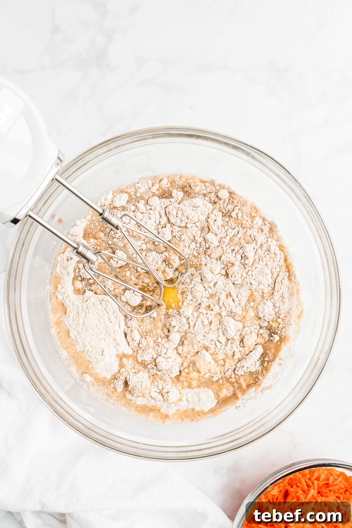 Ingredients for carrot cake in a large bowl.