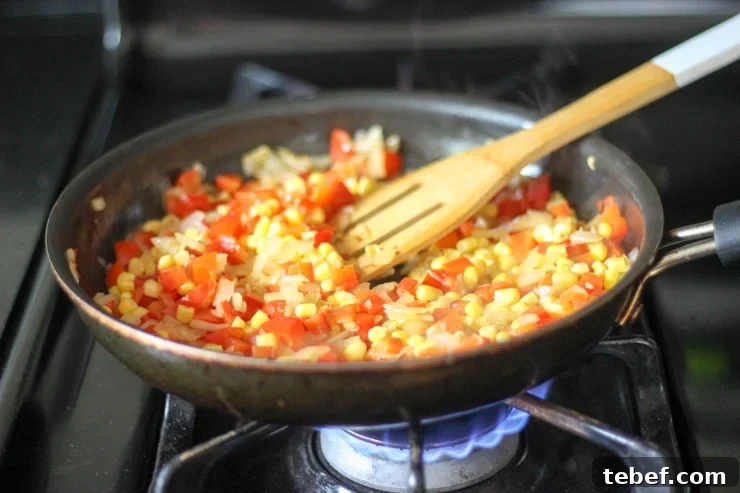 diced red pepper, onion and corn in a large pan