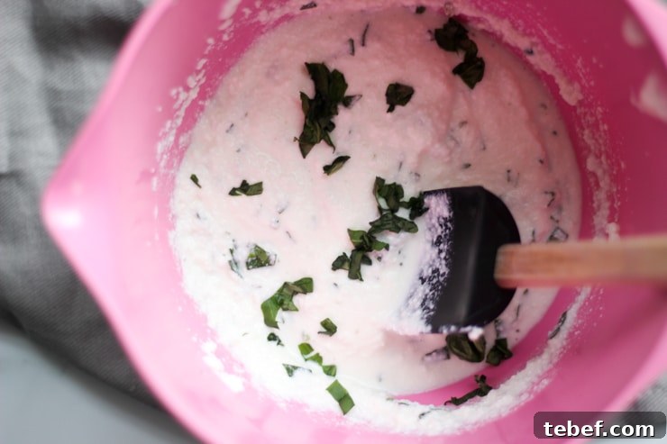 fresh whipped ricotta and basil in a pink kitchen bowl